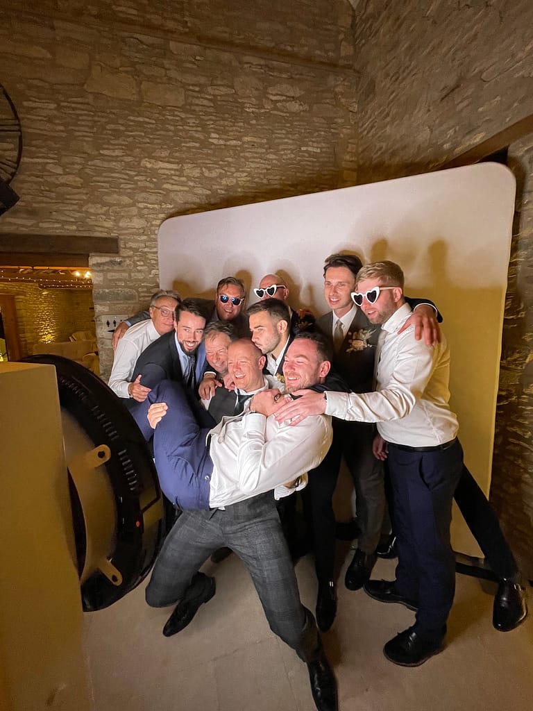 Guests pose in front of the photo booth at Caswell House in the Cotswolds